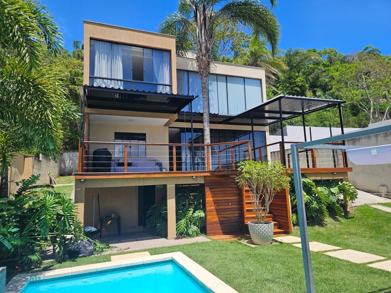 Casa com coberturas fixas de estrutura preta nas varandas